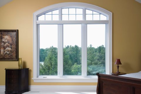 A white casement window with transom and grilles from Heritage Renovations.