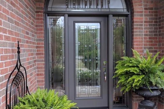 An entry door, sidelites and transom with door-sidelites-transom-Artisan Patina glass installed by Heritage Renovations in London, Ontario, and manufactured by Gentek.